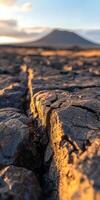 Cracked earth near a volcano at sunset highlighting volcanic landscape features photo