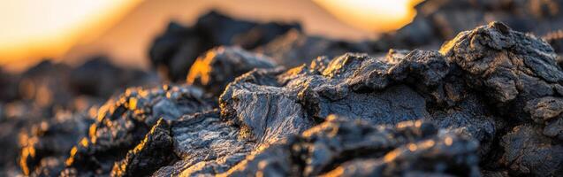 Lava rock formations illuminated by sunset near an active volcano photo