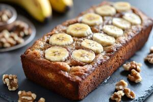 Homemade banana bread loaf decorated with banana slices and walnuts photo