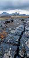 Expansive volcanic landscape showcasing cracked lava rock under gray clouds photo