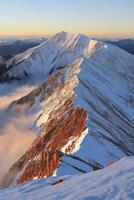 Majestic snowy mountain ridge at sunset photo