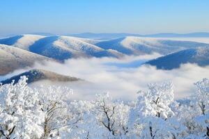 Snow-covered mountain landscape with fog photo