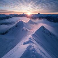 Snow-capped mountains at sunrise above clouds photo