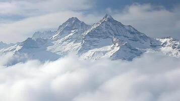 A snowy mountain range is seen in the clouds photo