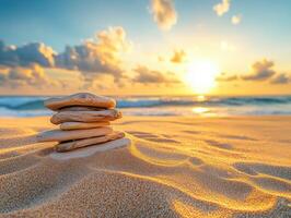Sunset over stacked stones on sandy beach photo