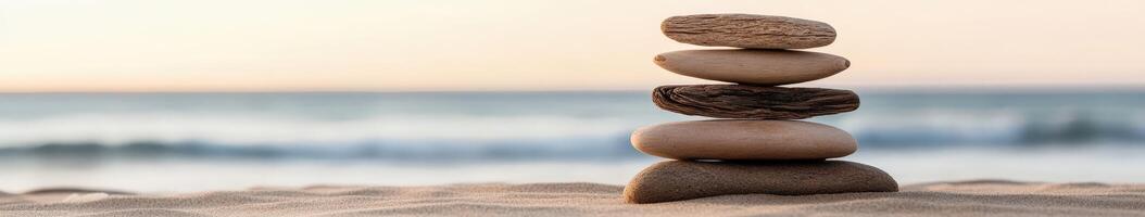 Stacked stones on a serene beach at sunset photo