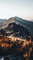 A mountain with grass and rocks on top photo