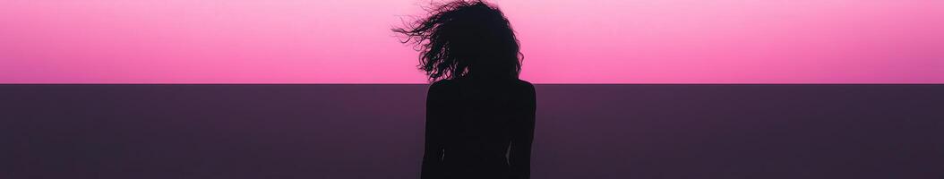 A black woman standing in front of a pink background photo