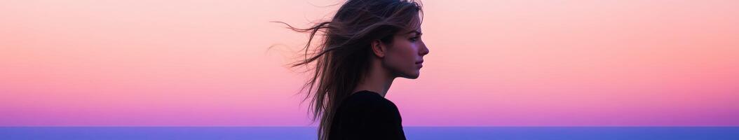 A woman with long hair standing in front of a sunset photo