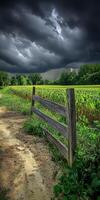 A fence in a field with dark clouds in the background photo
