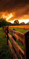 A wooden fence in a field at sunset photo