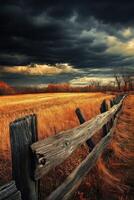 A wooden fence in a field with a stormy sky photo