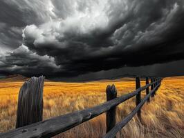 A fence and a stormy sky in the middle of a field photo