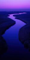 A river flows through a marsh at dusk photo