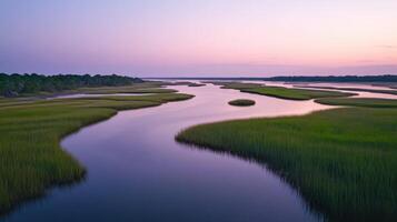 A river runs through a marsh at sunset photo