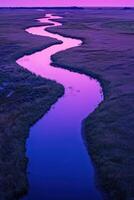 A river runs through a marsh at sunset photo