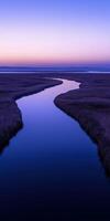 A river runs through a marsh at sunset photo