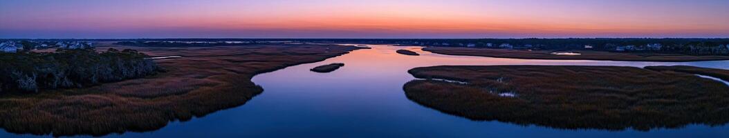 A river runs through a marsh at sunset photo