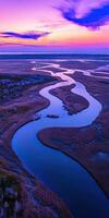 A river runs through a marsh at sunset photo