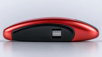 Sleek red wireless mouse on a smooth surface, showcasing modern design and technology photo