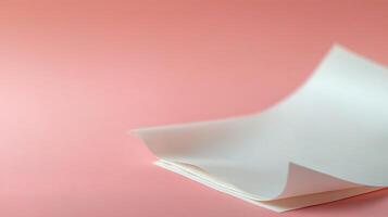 A soft, curled sheet of paper resting on a smooth pink background, creating a calm ambiance photo