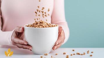 Woman pouring cereal from a bowl into the air, with a soft pastel background, conveying a joyful breakfast moment photo