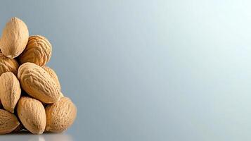 A close-up view of a pile of almonds on a soft gradient background, showcasing their natural texture photo