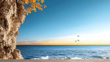 Serene coastal view at sunset with rocky cliff, gentle waves, and flying birds in the background photo