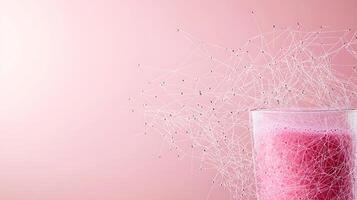 Refreshing pink beverage in a glass with abstract network design on a soft pink background photo