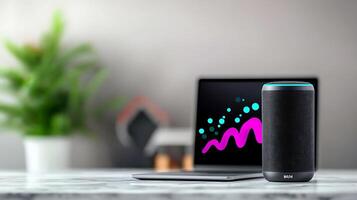 Modern workspace featuring a sleek speaker and laptop with vibrant digital art background photo