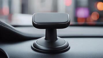 Sleek car phone mount positioned on dashboard with blurred city lights in background photo