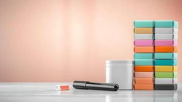 A neatly arranged stack of colorful boxes beside a white container and a black pen on a smooth surface photo