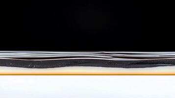 Close-up view of dark liquid layer above light liquid, highlighting texture and color contrast photo