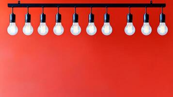 Row of glowing light bulbs hanging against a vibrant red wall, creating a warm ambiance photo