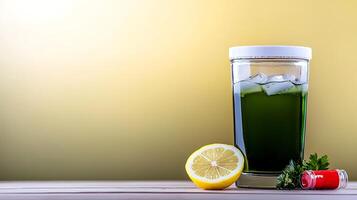 Refreshing green beverage in a glass with ice, lemon slice, and herbs on a wooden surface photo