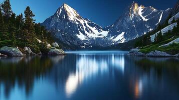Serene mountain landscape at twilight with reflections in calm lake and snow-capped peaks photo