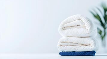 Soft, neatly folded blankets in a serene, minimalistic setting with greenery in the background photo