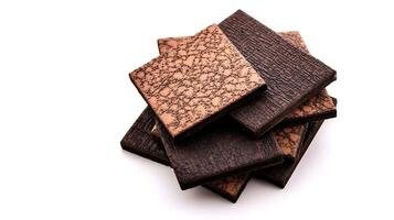 Stacked textured chocolate tiles showcasing rich colors and patterns against a white backdrop photo