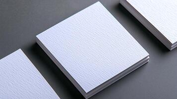 Stacked blank sheets of textured paper on a dark surface, ideal for design mockups or presentations photo