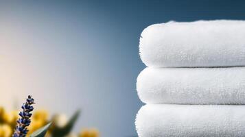 Stacked white towels with lavender and yellow flowers in a serene spa-like setting photo