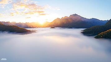 Sunrise over a misty valley with mountains in the background, creating a serene landscape photo