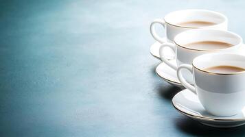 Three elegant coffee cups with saucers arranged on a blue surface, creating a serene atmosphere photo