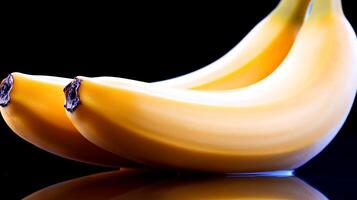 Two ripe bananas resting on a reflective surface against a dark background, showcasing freshness photo