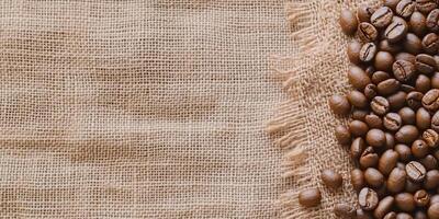 Coffee beans scattered on a textured burlap fabric background. photo