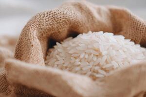 A mound of uncooked white rice nestled in a burlap cloth. photo