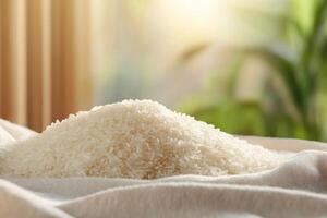A mound of uncooked white rice on a soft cloth with a blurred background. photo