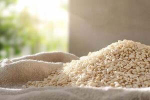 A pile of sesame seeds on a textured cloth, softly illuminated. photo