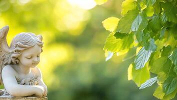 A serene angel statue amidst lush green leaves in soft sunlight. photo