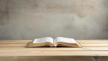 An open book resting on a wooden table against a neutral background. photo