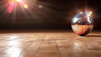 A reflective disco ball on a wooden floor, illuminated by light rays. photo